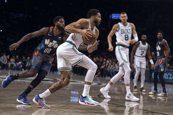 Boston Celtics' Jayson Tatum drives to the basket past Brooklyn Nets' Royce O'Neale, left, during an NBA basketball game Saturday, Nov. 4, 2023, in New York. (AP Photo/Andres Kudacki)