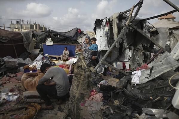 Displaced Palestinians inspect their tents destroyed by Israel's bombing next to a UNRWA facility west of the Gaza Strip town of Rafah, Tuesday, May 28, 2024. (AP Photo/Jehad Alshrafi)