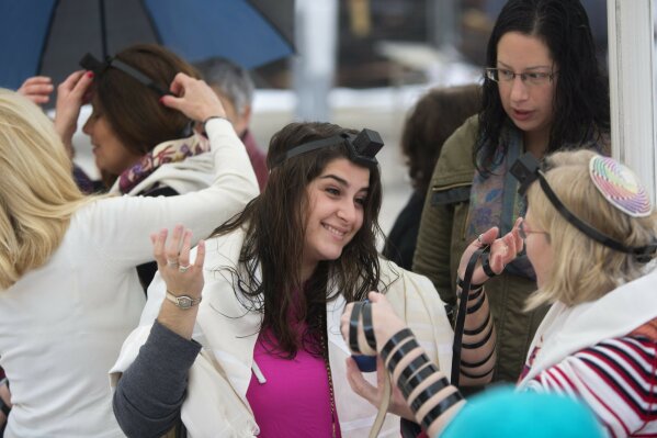 
              FILE - In this Feb. 7, 2016, file photo, Israeli women wear Tefillin, also known as Phylacteries - small leather boxes containing religious texts usually worn by Jewish men, at the Western Wall, the holiest site where Jews can pray in Jerusalem's Old City. (AP Photo/Sebastian Scheiner, File)
            