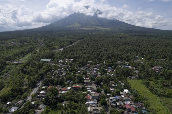 Homes are seen near the permanent danger zone surrounding Mayon volcano at Bonga village, Albay province, northeastern Philippines, on June 15, 2023. Thousands of poor Filipinos risk their lives by living and working in villages inside a permanent danger zone around Mayon volcano. (AP Photo/Aaron Favila)