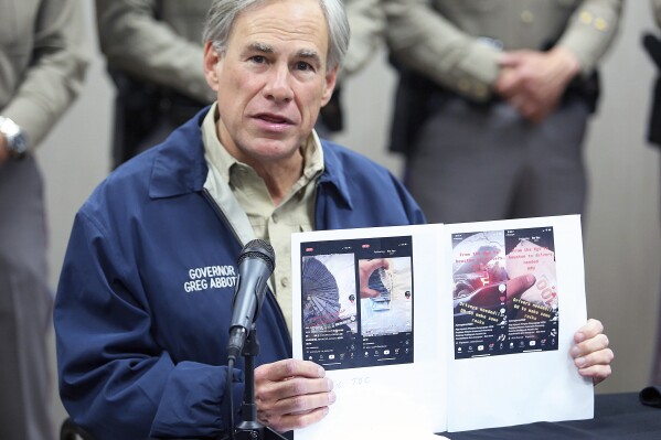 FILE - Texas Gov. Greg Abbott displays screen shots of TikTok videos used by organized crime to recruit members gathered by law enforcement as he talks about Operation Lone Star during a news conference, April 1, 2021, in Weslaco, Texas. A First Amendment group sued Gov. Abbott and others on Thursday, July 13, 2023 over the state’s TikTok ban on official devices. The lawsuit was filed in a federal court in Texas by The Knight First Amendment Institute at Columbia University, a free speech group in New York. (Joel Martinez/The Monitor via AP, file)