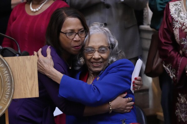 Former Mississippi State Rep. Alyce Clarke, D-Jackson, right, hugs State Rep. Tamarra Grace Butler-Washington, D-Jackson, after her comments at the ceremony where Clarke's official portrait in the Mississippi State Capitol was unveiled, Tuesday, Feb. 13, 2024, in Jackson. Butler-Washington was elected to the seat that Clarke retired from last year. Clarke is the first woman and the first African American to have a portrait displayed in the state Capitol. (AP Photo/Rogelio V. Solis)