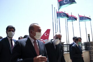 FILE - In this June 17, 2020, file photo, Turkey's Foreign Minister Mevlut Cavusoglu, left, and Muhammed Tahir Siyala, Foreign Minister of Libya's internationally-recognized government, speak at the airport, in Tripoli, Libya. Libya’s eastern-based forces have lost the chance to engage in a political solution to the North African country’s conflict, Turkey's foreign minister said Saturday, June 20, 2020. (Fatih Aktas/Turkish Foreign Ministry via AP, Pool, File)