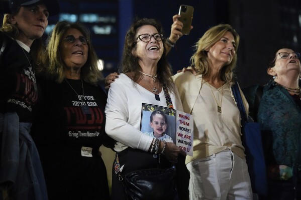 People react as they hear the news of the release of 13 Israeli hostages held by Hamas in the Gaza strip, in Tel Aviv, Israel, on Friday, Nov. 24, 2023. Friday marks the start of a four-day cease-fire in the Israel-Hamas war, during which the Gaza militants pledged to release 50 hostages in exchange for 150 Palestinians imprisoned by Israel. (AP Photo/Ariel Schalit)