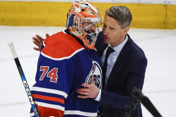 Edmonton Oilers goalie Stuart Skinner (74) is congratulated by head coach Kris Knoblauch after defeating the Dallas Stars in Game 6 of the Western Conference finals of the NHL hockey Stanley Cup playoffs in Edmonton, Alberta, Sunday, June 2, 2024. (Jeff McIntosh/The Canadian Press via AP)