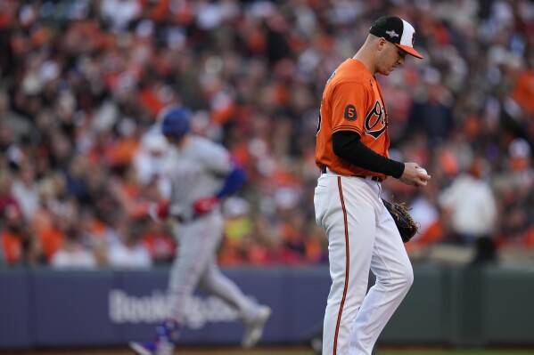 Baltimore Orioles relief pitcher Jacob Webb, right, reacts after giving up a grand slam to Texas Rangers' Mitch Garver, left, during the third inning in Game 2 of an American League Division Series baseball game, Sunday, Oct. 8, 2023, in Baltimore. (AP Photo/Julio Cortez)