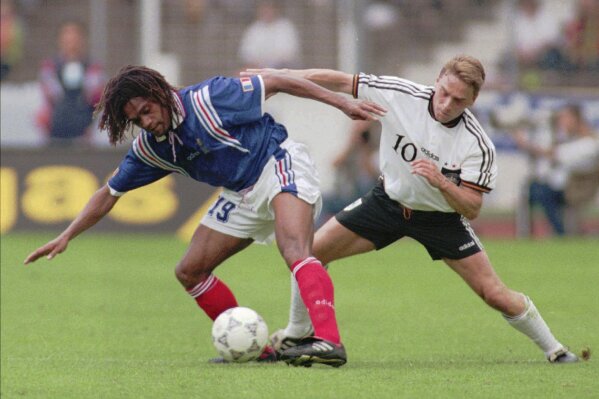 FILE - Christian Karembeu of France, left, protects the ball during the international soccer match between Germany and France at Stuttgart, Germany, Saturday, June 1, 1996. Former international soccer player Christian Karembeu, a 1998 World Cup and Euro 2000 winner with France, says two of his relatives have been killed during the unrest in the French Pacific territory of New Caledonia that has left seven people dead. (AP Photo/Thomas Kienzle, File)