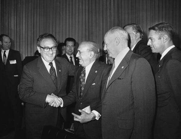BESTAND - De Amerikaanse minister van Buitenlandse Zaken Henry Kissinger begroet de Argentijnse minister van Buitenlandse Zaken, Alberto J. Vignes, terwijl Ismael Huerta Diaz (rechts, ministers van Buitenlandse Zaken van Chili) toekijkt tijdens de pauze op de Latijnse ministersconferentie van Buitenlandse Zaken in Mexico-Stad, 22 februari 1974. Linksen in Chili werden ze gemarteld tijdens de militaire dictatuur van generaal Augusto Pinochet, en in Argentinië werden velen gemarteld "verdwenen" door leden van de meedogenloze militaire dictatuur die gevangenen in concentratiekampen vasthield.  Het gebeurde allemaal met de steun van Henry Kissinger, de voormalige Amerikaanse minister van Buitenlandse Zaken.  Veel landen zijn tijdens de Koude Oorlog diep getekend door mensenrechtenschendingen in naam van het anticommunisme en waar velen nog steeds een diep wantrouwen koesteren jegens hun machtige buurland in het noorden.  (AP Foto/Ed Kolenovsky, bestand)