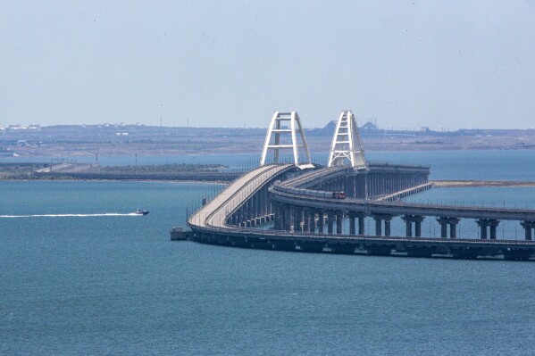 A freight train runs on rails of a railway link of the Crimean Bridge connecting Russian mainland and Crimean peninsula over the Kerch Strait not far from Kerch, Crimea, on Monday, July 17, 2023. An attack before dawn damaged part of a bridge linking Russia to Moscow-annexed Crimea that is a key supply route for Kremlin forces in the war with Ukraine. The strike Monday has forced the span's temporary closure for a second time in less than a year. (AP Photo)