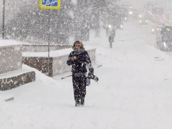 A man walks down a street during heavy snowfall in Moscow, Russia, Monday, Dec. 4, 2023. A record snowfall has hit Russia's capital bringing an additional 10 cm (3,9 inches) to already high levels of snow and causing disruption at the capital's airports and on roads. (Denis Voronin/Moscow News Agency via AP)