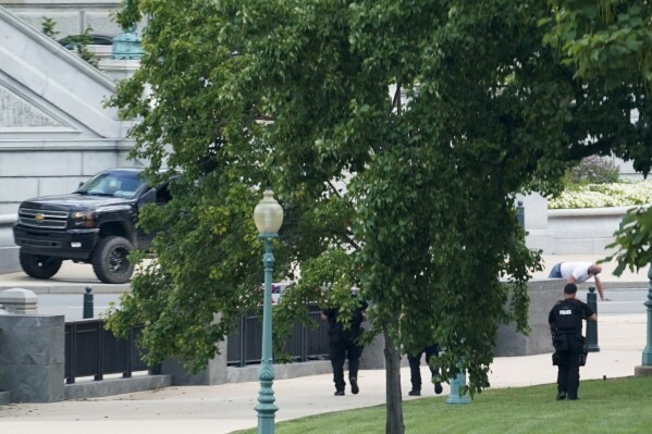 FILE - A man is apprehended after being in a pickup truck parked on the sidewalk in front of the Library of Congress' Thomas Jefferson Building, as seen from a window of the U.S. Capitol, Aug. 19, 2021, in Washington. A man whose bomb threat near the U.S. Capitol forced evacuations and sparked an hourslong standoff with police in 2021 was sentenced to five years of probation Friday, Sept. 15, 2023. Floyd Ray Roseberry was experiencing a mental-health crisis at the time of the threat, and during the year that he served in jail after his arrest he stopped a violent assault on a guard, U.S. District Judge Rudolph Contreras said. (AP Photo/Alex Brandon, File)