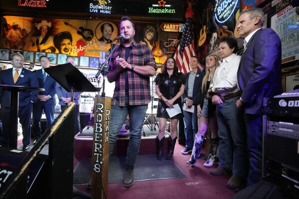 Country music star Luke Bryan speaks during a bill signing ceremony with Gov. Bill, right, on Thursday, March 21, 2024, in Nashville, Tenn. The legislation is designed to protect songwriters, performers and other music industry professionals against the potential dangers of artificial intelligence. The signing took place in Robert's Western World, an historic honky tonk in downtown Nashville. (AP Photo/Mark Humphrey)