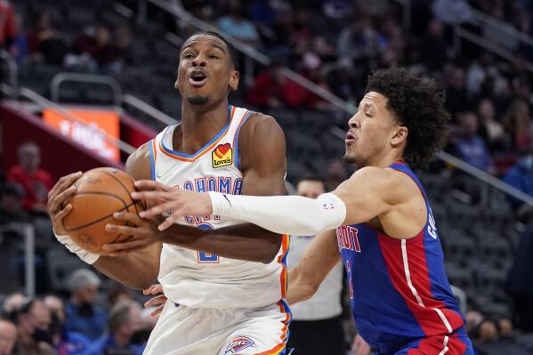 Detroit Pistons guard Cade Cunningham (2) reaches in on Oklahoma City Thunder guard Shai Gilgeous-Alexander (2) during the second half of an NBA basketball game, Monday, Dec. 6, 2021, in Detroit. (AP Photo/Carlos Osorio)