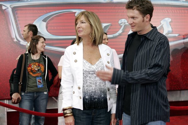 
              FILE - In this May 26, 2006, file photo, NASCAR driver Dale Earnhardt Jr., right, and his mother Brenda Jackson, front left, arrive for the premiere of the Disney/Pixar animated film "Cars" at Lowe's Motor Speedway in Concord, N.C. Jackson, a longtime employee at JR Motorsports, has died following a battle with cancer. She was 65. The team announced her death Monday, April 22, 2019. (AP Photo/Chuck Burton, File)
            