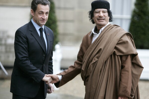 FILE - French President Nicolas Sarkozy, left, greets Libyan leader Col. Moammar Gadhafi upon his arrival at the Elysee Palace, in Paris Dec. 10, 2007. French investigative magistrates on Friday, Aug. 25, 2023, ordered former president Nicolas Sarkozy and 12 others to go on trial on charges that his 2007 presidential campaign received millions in illegal financing from the government of late Libyan leader Moammar Gadhafi. (AP Photo/Francois Mori, File)