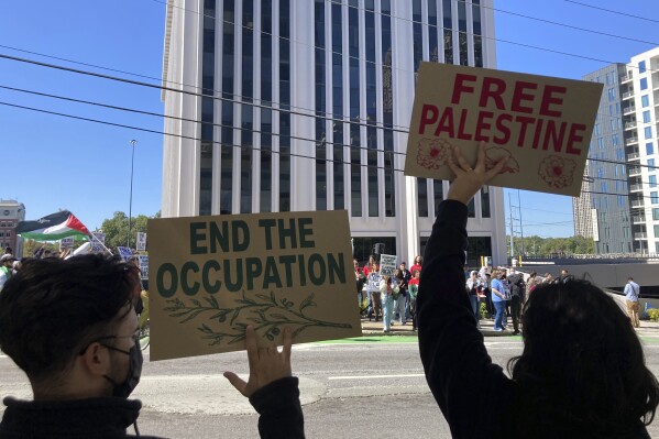 FILE - Pro-Palestinian demonstrators chant slogans outside the Israeli consulate in Atlanta on Sunday, Oct. 8, 2023. For Palestinian Americans, there’s a sense of helplessness and hopelessness as many struggle to hear from their families in Gaza. Amid a fuel and water shortage, no electricity, and now a forced evacuation in the north, administering and sending aid to civilians in Gaza is near impossible. (AP Photo/Jeff Amy, File)