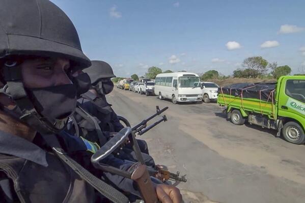 In this image made from video, Rwandan police patrol a road in Palma, Cabo Delgado province, Mozambique, Sunday Aug. 15, 2021. A new offensive by Mozambique's Islamic extremist rebels in Cabo Delgado has increased the number of displaced by 80,000 and undermines the government's claims of containing the insurgency. (AP Photo/Marc Hoogsteyns)