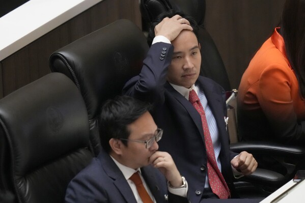 Pita Limjaroenrat, right, the leader of Move Forward Party and top winner in the May's general election, reacts during vote counting at the Parliament in Bangkok, Thailand, Thursday, July 13, 2023. Pita, whose Move Forward Party ran first in Thailand's May 14 general election, was nominated to be prime minister at a joint session of Parliament's Upper and Lower House on Thursday, but failed to attain the majority vote needed to win the job, necessitating a new round of voting expected next week. (AP Photo/Sakchai Lalit)