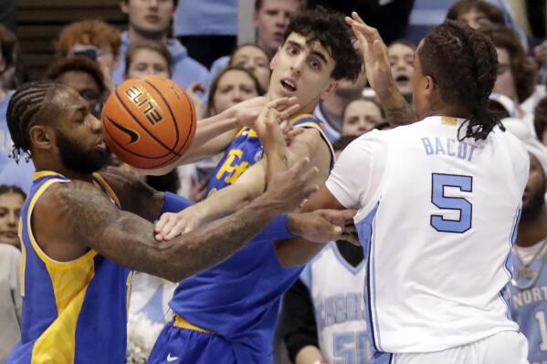 Pittsburgh guard Jamarius Burton, left, and Pittsburgh forward Guillermo Diaz Graham, center, battle North Carolina forward Armando Bacot (5) for a rebound during the second half of an NCAA college basketball game Wednesday, Feb. 1, 2023, in Chapel Hill, N.C. (AP Photo/Chris Seward)