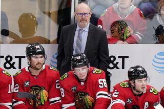 FILE - Chicago Blackhawks interim head coach Derek King and players watch during the third period of an NHL hockey game against the Anaheim Ducks, on, Jan. 15, 2022, in Chicago. The Blackhawks are taking an unusual approach to their search for their next general manager and plan to make a decision before the NHL trade deadline in March. Blackhawks CEO Danny Wirtz says the interview process will include candidates “both inside and outside of hockey.” (AP Photo/Nam Y. Huh, File)