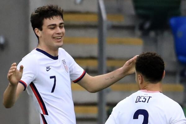 FILE - United States's Gio Reyna, left, celebrates with United States's Sergino Dest after scoring his side's opening goal during an international friendly soccer match between Northern Ireland and United States, at Windsor Park, Belfast, Northern Ireland, Sunday, March 28, 2021.  Reyna's could get to play in the Europa League against the team managed by the person he was named after. Reyna, a 19-year-old who debuted for Dortmund last year, was named after Giovanni van Bronckhorst, a teammate of his dad, Claudio Reyna, at Scotland's Glasgow Rangers from 1999-2001.(AP Photo/Peter Morrison, File)