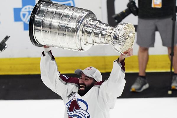 CORRECTS ID TO NAZEM KADRI INSTEAD OF NATHAN MACKINNON - Colorado Avalanche center Nazem Kadri lifts the Stanley Cup after the team defeated the Tampa Bay Lightning 2-1 in Game 6 of the NHL hockey Stanley Cup Finals on Sunday, June 26, 2022, in Tampa, Fla. (AP Photo/John Bazemore)
