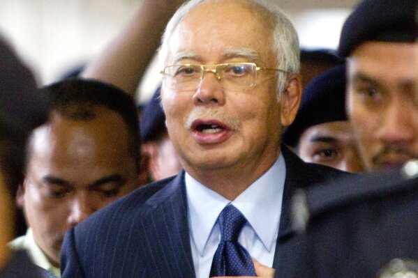 
              FILE - In this Sept. 20, 2018, file photo, former Malaysian Prime Minister Najib Razak walks out of courtroom after a court hearing at Kuala Lumpur High Court in Kuala Lumpur, Malaysia. Malaysia says it has filed criminal charges against Goldman Sachs and two of its employees in connection with a multibillion-dollar scandal involving state investment fund 1MDB. Najib launched 1MDB in 2009 to promote economic development but it racked up billions of dollars in debts that have led to investigations in the U.S. and several other countries. (AP Photo/Yam G-Jun, FIle)
            