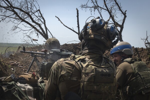 FILE - Ukrainian soldiers fire toward Russian position from a trench on the frontline in Zaporizhzhia region, Ukraine, Friday, June 23, 2023. In the southeastern Zaporizhzhia region, Ukrainian troops - backed by tanks, artillery and drones - have broken through initial Russian fighting positions and continue to make steady gains south of Velyka Novosilka near the administrative border with Donestk and south of Orikhiv, while confronting heavy bombardment in wide open fields with little cover. (AP Photo/Efrem Lukatsky, File)