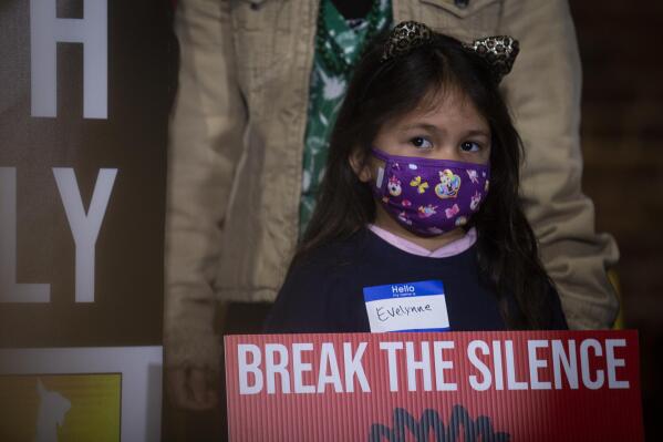 A child holds a sign at the beginning of a rally on Wednesday, March 16, 2022, in Atlanta. The Atlanta Asian Justice Rally was held on the anniversary of violence that left eight people shot and killed at various massage businesses on March 16, 2021, in the Atlanta area. Many family members and friends of the victims have been struggling with grief, trying to heal and making sure their loved ones aren't forgotten. (AP Photo/Ron Harris)
