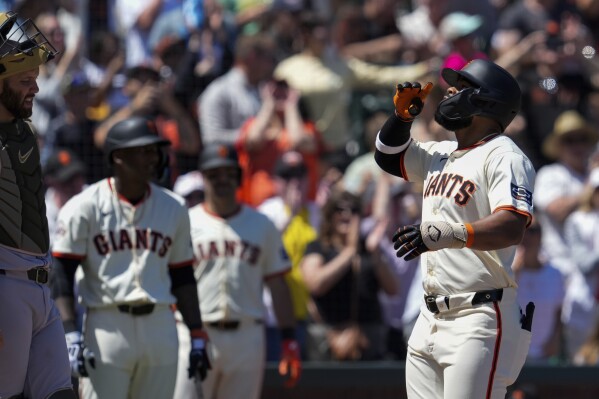 San Francisco Giants' Heliot Ramos, right, celebrates next to Colorado Rockies catcher Jacob Stallings, left, after hitting a solo home run during the sixth inning of a baseball game Sunday, May 19, 2024, in San Francisco. (AP Photo/Godofredo A. Vásquez)