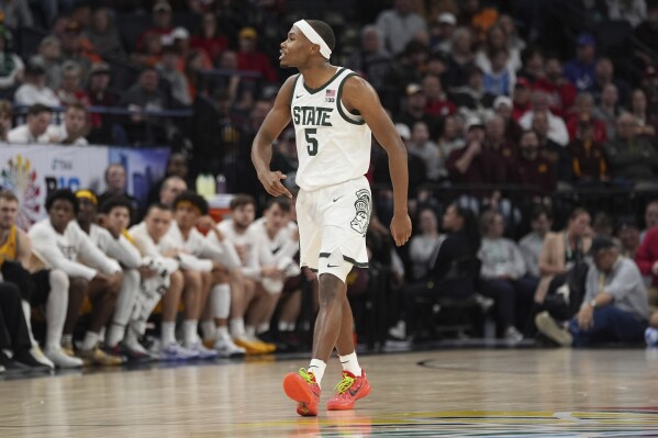 Michigan State guard Tre Holloman (5) gestures after making a 3-point basket during the second half of an NCAA college basketball game against Minnesota in the second round of the Big Ten Conference tournament, Thursday, March 14, 2024, in Minneapolis. (AP Photo/Abbie Parr)