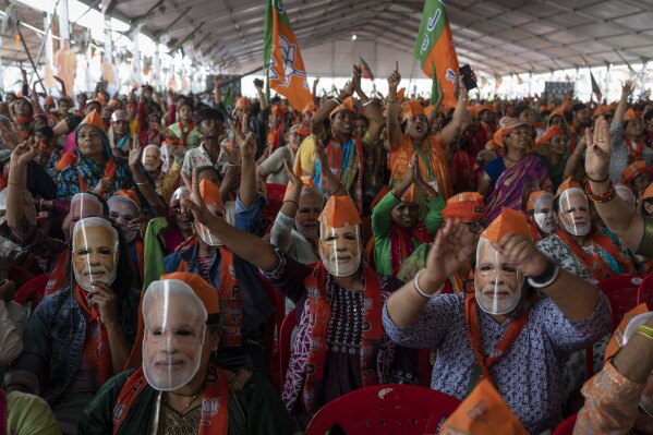 Los partidarios del Partido Bharatiya Janata (BJP) usan máscaras del primer ministro indio Narendra Modi durante un mitin electoral dirigido por Modi en Meerut, India, el domingo 31 de marzo de 2024. (Foto AP/Altaf Qadri)