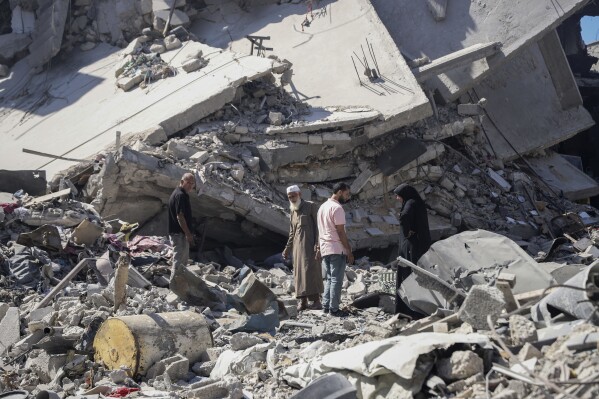 Palestinians sift through the rubble of their home in the wake of an Israeli air and ground offensive in Jebaliya, northern Gaza Strip after Israeli forces withdrew from the area, Friday, May 31, 2024. (AP Photo/Enas Rami)
