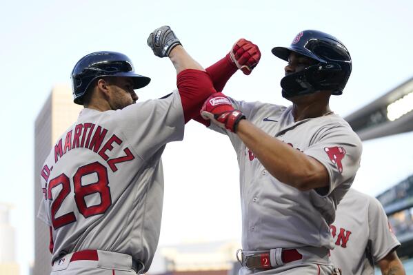Boston Red Sox's Xander Bogaerts, right, celebrates with J.D. Martinez after hitting a grand slam during the third inning of the team's baseball game against the Minnesota Twins, Wednesday, Aug. 31, 2022, in Minneapolis. (AP Photo/Abbie Parr)