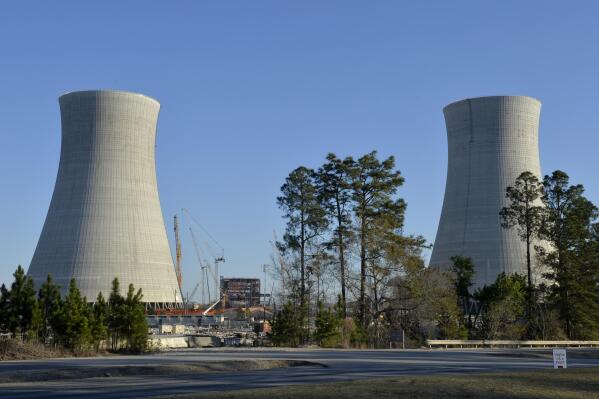 FILE - The cooling towers of the still under construction Plant Vogtle nuclear energy facility in Waynesboro, Ga., Friday, March 22, 2019.   One of the owners of the plant announced Saturday, June 18, 2022, that it was freezing its costs and forcing Georgia Power Co. to assume all future overruns, giving up a share of its ownership to Georgia Power.  (Michael Holahan/The Augusta Chronicle via AP)