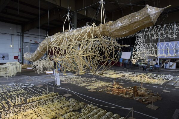 Dutch artist Theo Jansen's 'strandbeesten' or Beach Beasts, wind-powered creatures made from yellow plastic tubes, are displayed during an exhibit in Delft, Netherlands, Thursday, June 5, 2025. (AP Photo/Peter Dejong)