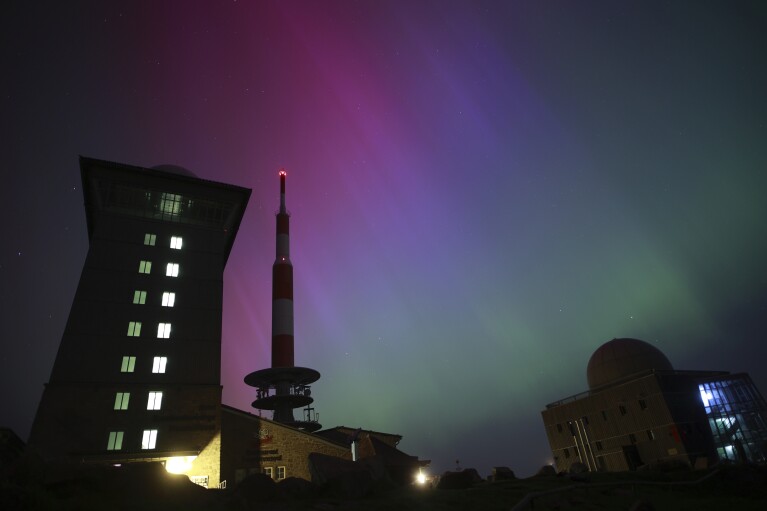 Northern lights appear in the night sky above the Brocken early Saturday, May 11, 2024, in Schierke, northern Germany. (Matthias Bein/dpa via AP)