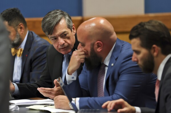 Kenneth Chesebro, left, confers with is lawyer Scott Grubman, as Judge Scott MacAfee presides as the lawyers of Sidney Powell and Chesebro appear during a motions hearing in the election subversion case Tuesday, Oct. 10, 2023, in Atlanta. Powell and Chesebro, indicted in August along with Trump and others, are accused of participating in a wide-ranging scheme to illegally try to overturn the results of the 2020 presidential election, which Donald Trump, the Republican incumbent, had lost to Democrat Joe Biden. (Alyssa Pointer/Pool Photo via AP)