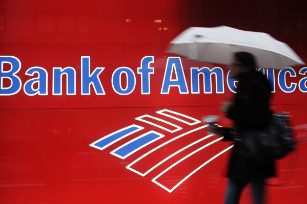 FILE - In this Dec. 7, 2012 photo, a woman passes a Bank of America office branch, in New York. Bank of America reports earnings on Tuesday, Oct. 17, 2023. (AP Photo/Mark Lennihan, File)