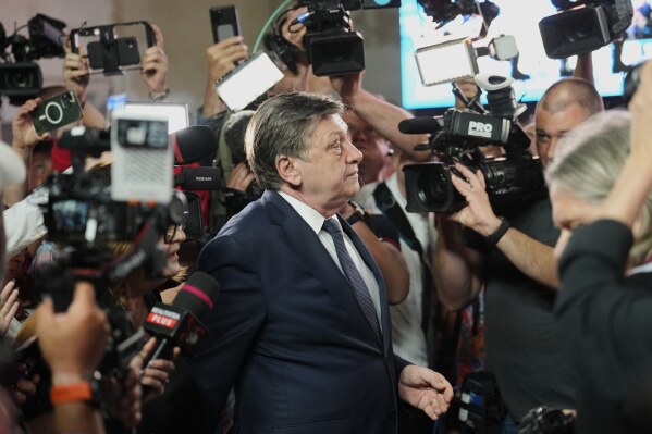 Presidential candidate Crin Antonescu walks surrounded by media shortly before polls closing during the first round of the country's presidential election redo in Bucharest, Romania, Sunday, May 4, 2025. (AP Photo/Vadim Ghirda)