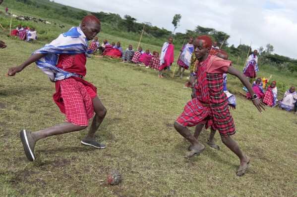 Children of the Maasai tribe play football in an open field, during the Enkipaata ceremony, a Maasai male rite of passage, specifically the initiation of boys, marking the transition from childhood to becoming a moran (warrior) in Olaimutiai, Narok County, Kenya Thursday, April 24, 2024. (AP Photo/Brian Inganga)
