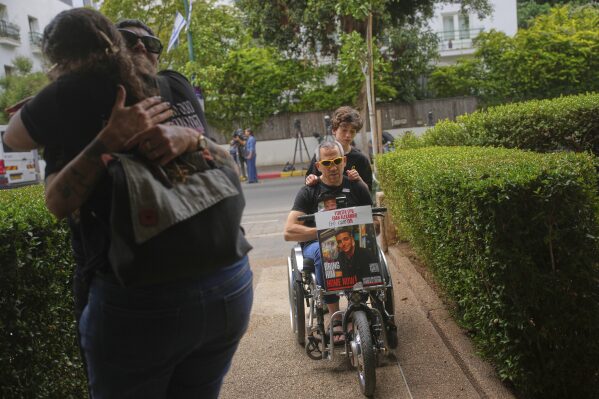 Doron, in a wheelchair, arrives along with friends and relatives to Israeli-American soldier Edan Alexander's family house ahead of his release from Hamas captivity in Gaza, in Tel Aviv, Monday, May 12, 2025. Alexander was abducted during the Hamas-led attack on his base on October 7, 2023. (AP Photo/Ohad Zwigenberg)