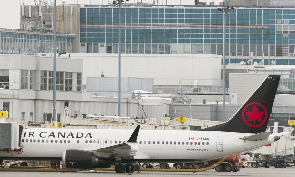 
              An Air Canada Boeing 737 Max 8 aircraft is parked next to a gate at Trudeau Airport in Montreal, Wednesday, March 13, 2019. Canada's transport minister says the country is closing air space to the Boeing 737 Max 8 jet following the crash of an Ethiopian Airlines jetliner. (Graham Hughes/The Canadian Press via AP)
            