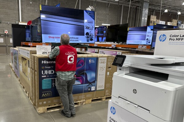 An associate checks over a big-screen television on display in a Costco warehouse Tuesday, Feb. 6, 2024, in Colorado Springs, Colo. On Tuesday, The Labor Department issues its report on inflation at the consumer level in January. (APPhoto/David Zalubowski)