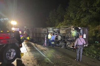 Police and rescue workers arrive on the scene of a bus crash late Sunday, Aug. 6, 2023, in Lower Paxton Township, Dauphin County ,Pa. The crash occurred between a passenger vehicle and charter bus carrying up to 50 passengers causing multiple fatalities and injuries. (Pennsylvania State Police via AP)