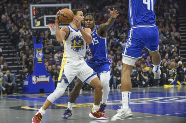 Golden State Warriors guard Stephen Curry (30) is guarded by Sacramento Kings guard Davion Mitchell (15) during the first quarter of an NBA In-Season Tournament basketball game in Sacramento, Calif., Tuesday, Nov. 28, 2023. (AP Photo/Randall Benton)
