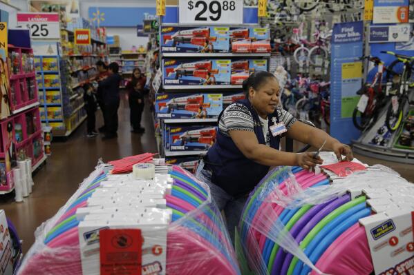 FILE - Balo Balogun labels items in preparation for a holiday sale at a Walmart Supercenter, Wednesday, Nov. 27, 2019, in Las Vegas.  Walmart plans to hire 40,000 U.S. workers for the holidays, a majority of them seasonal workers. The move announced Wednesday, Sept. 21, 2022,  comes as the nation’s largest retailer and largest private employer said it’s in a stronger staffing position heading into the holidays than last year.   (AP Photo/John Locher, File)