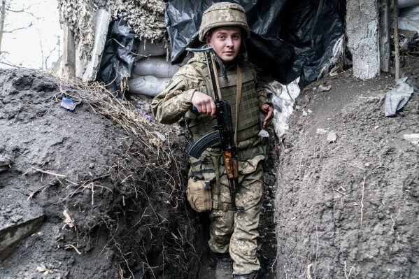 Ukrainian serviceman Serhiy Kochuk walks along a trench near the front-line town of Krasnohorivka, eastern Ukraine, Friday, March 5, 2021. In the front-line town of Krasnohorivka, soldiers widely refuse to vaccinate. "I have little faith in a pandemic, I don't think it's some kind of serious disease," said Serhiy Kochuk, a 25-year-old soldier who has been on duty at the front line. "I am healthy, but the vaccine can provoke illness; because of this vaccine you can get sick." (AP Photo/Evgeniy Maloletka)