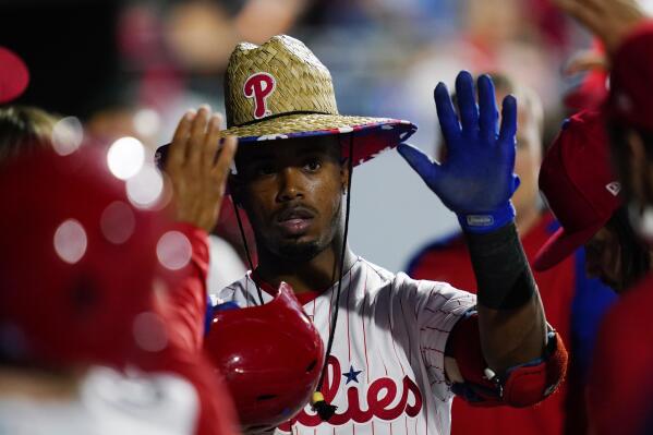 Philadelphia Phillies' Jean Segura celebrates in the dugout after hitting a home run off Colorado Rockies pitcher Kyle Freeland during the fifth inning of a baseball game, Saturday, Sept. 11, 2021, in Philadelphia. (AP Photo/Matt Slocum)