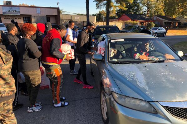 Friends of slain rapper Young Dolph distribute Thanksgiving turkeys outside St. James Missionary Baptist Church on Friday, Nov. 19, 2021, in Memphis, Tenn. The hip-hop artist and music label owner had helped organize the event, but he was fatally shot Wednesday inside a Memphis bakery. Police were searching for suspects Friday. (AP Photo/Adrian Sainz)